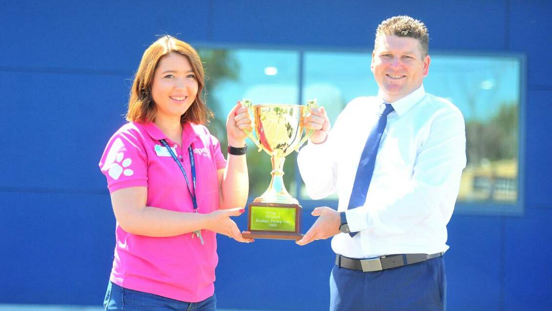 WINNING FEELING: PETstock Epsom manager Ruby Mines and Bendigo Harness Racing Club general manager Erik Hendrix with the 2019 Bendigo Pacing Cup. Picture: KIERAN ILES