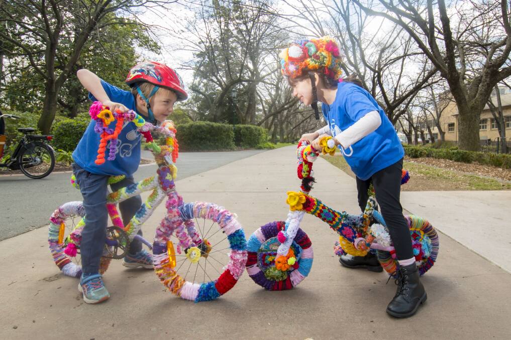 CLOSE-KNIT: Edwin Kretschmer and Isabella Torres-Gomez getting ready for this weekend's Bike Palooza with yarn-bombed bikes. Picture: DARREN HOWE  