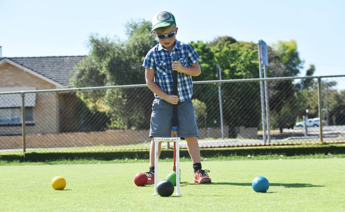 COME AND TRY: Logan Cattanach tries his hand at croquet. Picture: DARREN HOWE