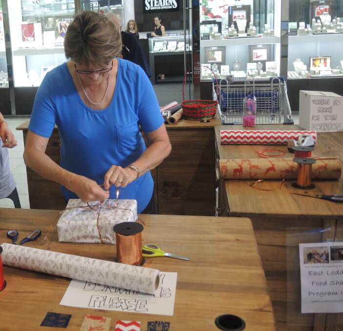 BUSY: Volunteer Julie Vecht wrapping presents. Picture: ANTHONY PINDA 
