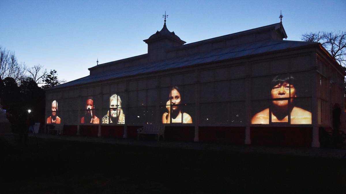 YAPENYA: Faces of Yapenya work is projected on the side of the conservatory in 2018. Picture: BENDIGO ADVETISER