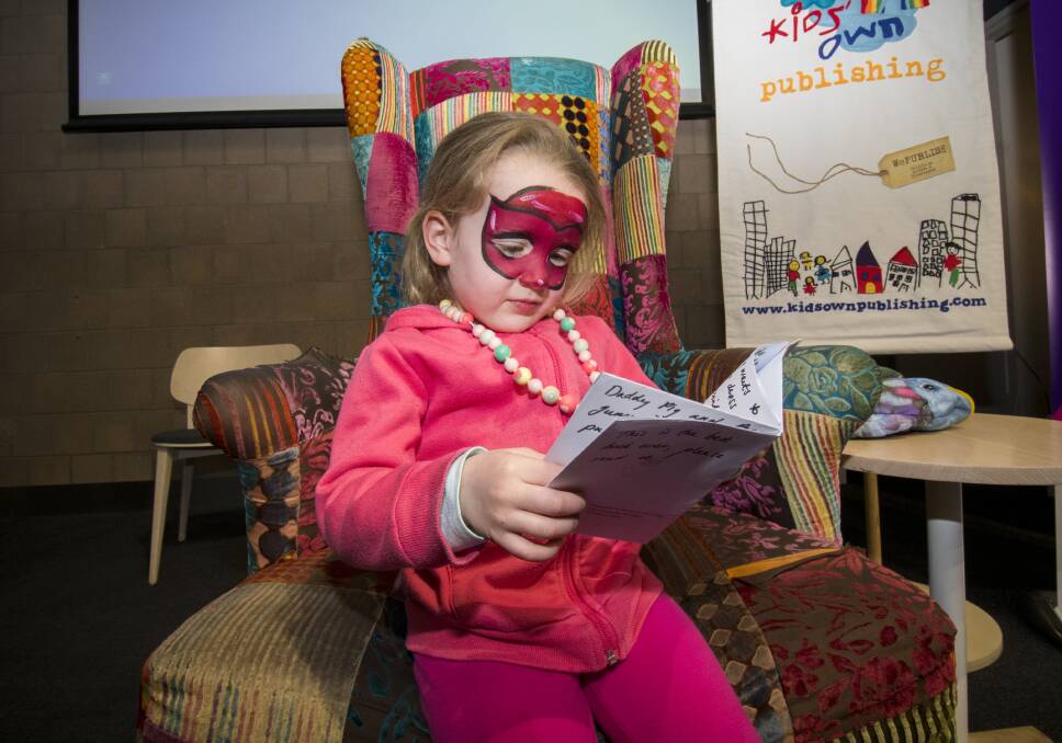 LITTLE READER: Issy Bartlett reading a book she wrote at Family Day on the Fringe at Bendigo Library, 2018. Picture: DARREN HOWE.
