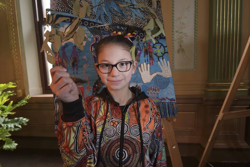 ARTWORK: Mia in front of collaborative artwork titled Seasons Freely. It was made by the BDAC women's group for NAIDOC Week last year. Picture: NONI HYETT