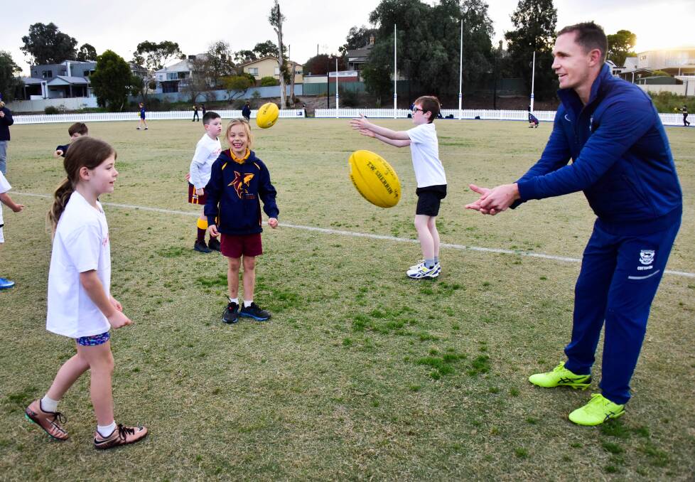 GRASSROOTS: Joel Selwood practices with Elsie Gretgrix and Perry Westley during the AFL star's visit to St Therese's Football Club on Wednesday. Picture: BRENDAN McCARTHY