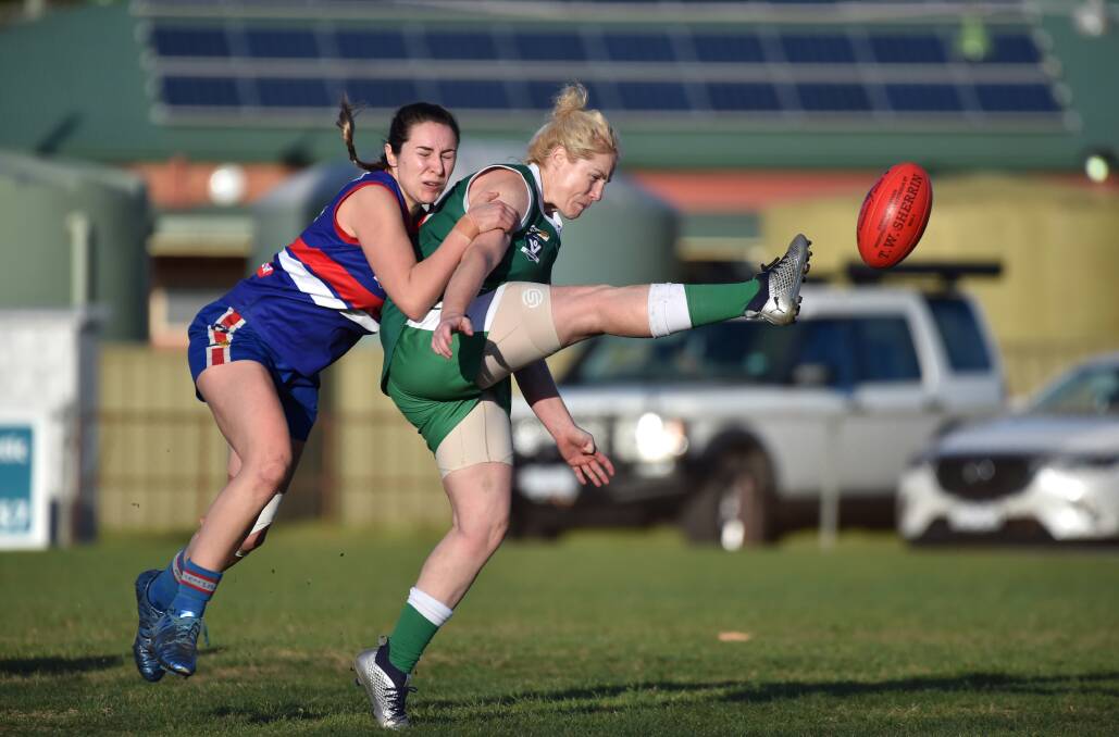 LEADER: Kangaroo Flat's Kelly Mensforth takes a kick under pressure from North Bendigo's Alana Long. Picture: GLENN DANIELS
