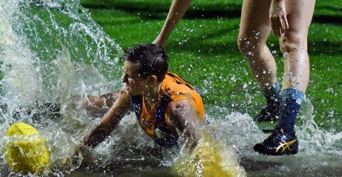 DOWNPOUR: Golden Square new recruit Michelle McCready dives for the ball during the rain-hampered CVFLW match against Eaglehawk on Friday night. Picture: NONI HYETT