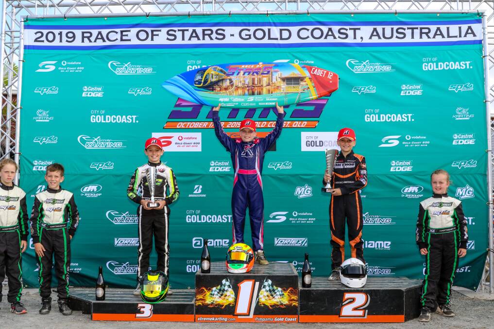 TOP PLACE FINISH: Harry Arnett with the surfboard held high on top of the Race of Stars podium. Picture: PACE IMAGES/BEN ROEHLEN