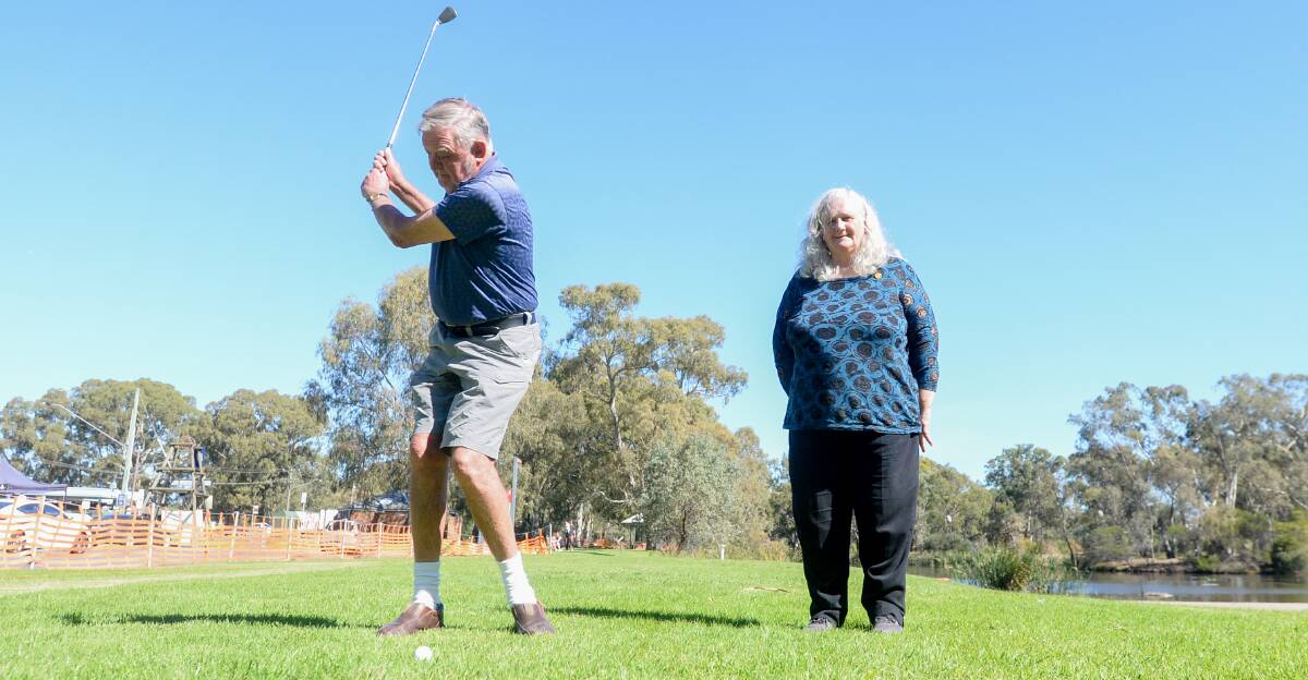 ACE: Rotary Club of Kangaroo Flat's Ian Doak hits a wedge shot towards the pin at Rotary Gateway Park while president Kaylyn Journeaux watches on. Picture: DARREN HOWE