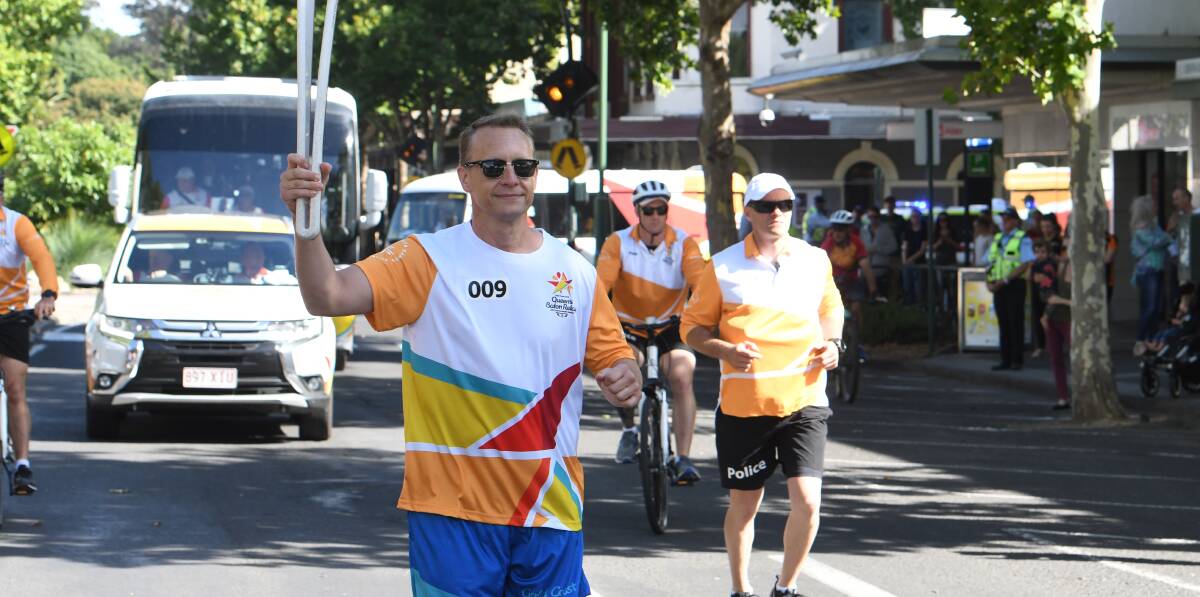 Colin Thompson carries the Queen's Baton through Bendigo in 2018 on the relay route to the Gold Coast Commonwealth Games.