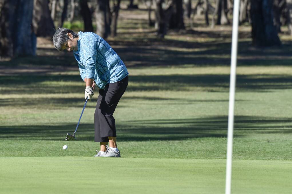 RIGHT TO LEFT: Bendigo Golf Club member Leanne Robertson makes a long-range putt from off the green.