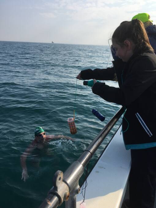 Crew support: Seirer's daughter Bridgette feeding him as he makes his first crossing of the English Channel in 2016.