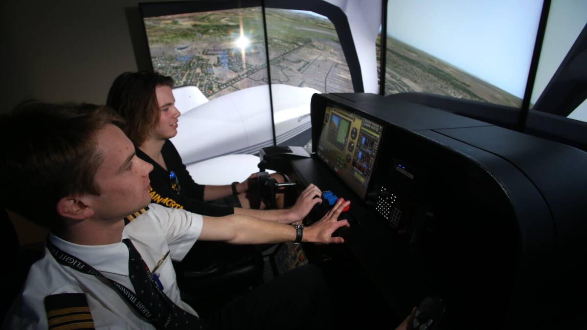 LEARNING TO FLY: Aspiring pilot Joshua Hamm (top) gets some instruction in RMIT new flight simulator from flight instructor Bronte Carter (below). Picture: GLENN DANIELS