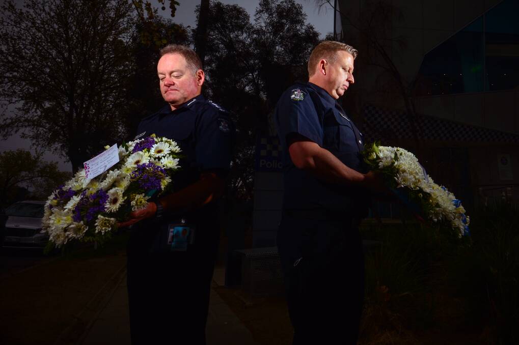 TRIBUTE: Acting Inspector Brian Hansen and Inspector Dan Davison with the wreaths officers laid for National Police Remembrance Day. Picture: DARREN HOWE