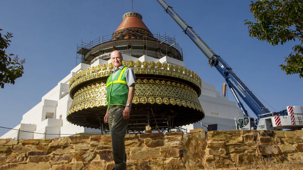 Ian Green with the gold-plated parasol installed on the stupa in December. Picture DARREN HOWE