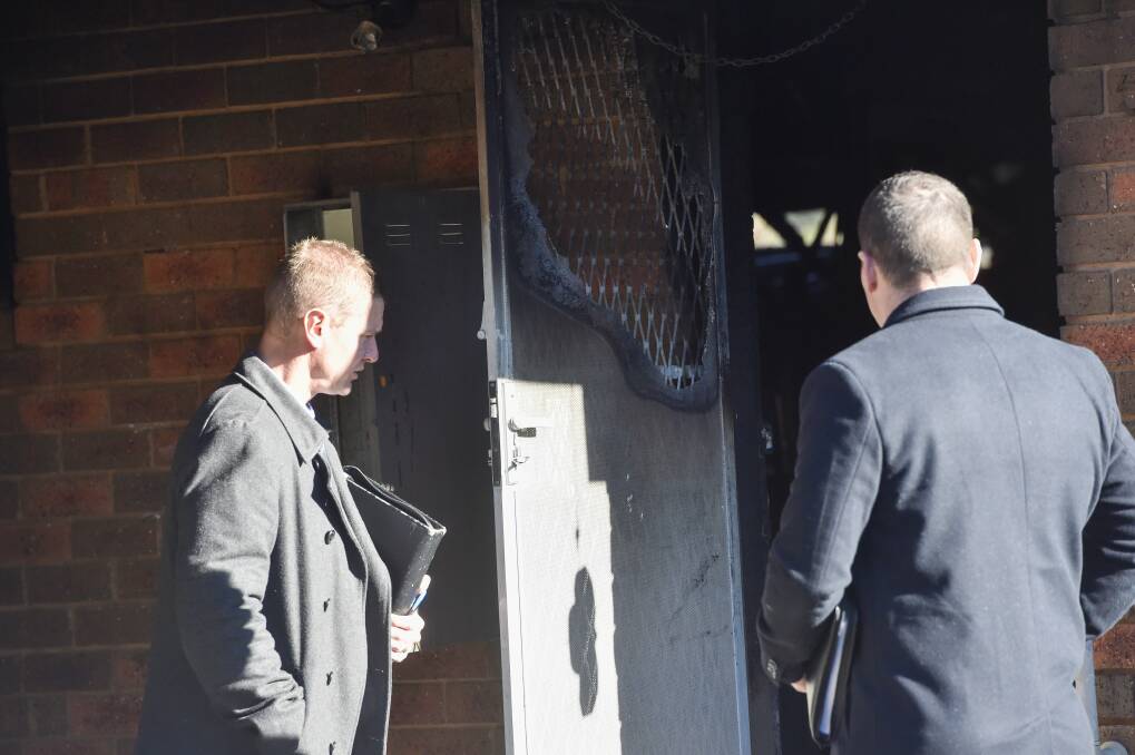 CAUSE: Police investigators examine the scene of a house fire on Lockwood Road, Kangaroo Flat, yesterday morning. Picture: DARREN HOWE