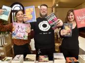 PAGE TURNERS: Bendigo Writers Festival volunteers Jesse Munzel, David Plathe and Shelley Job set up the festival's book store ahead of the first day. Picture: NONI HYETT