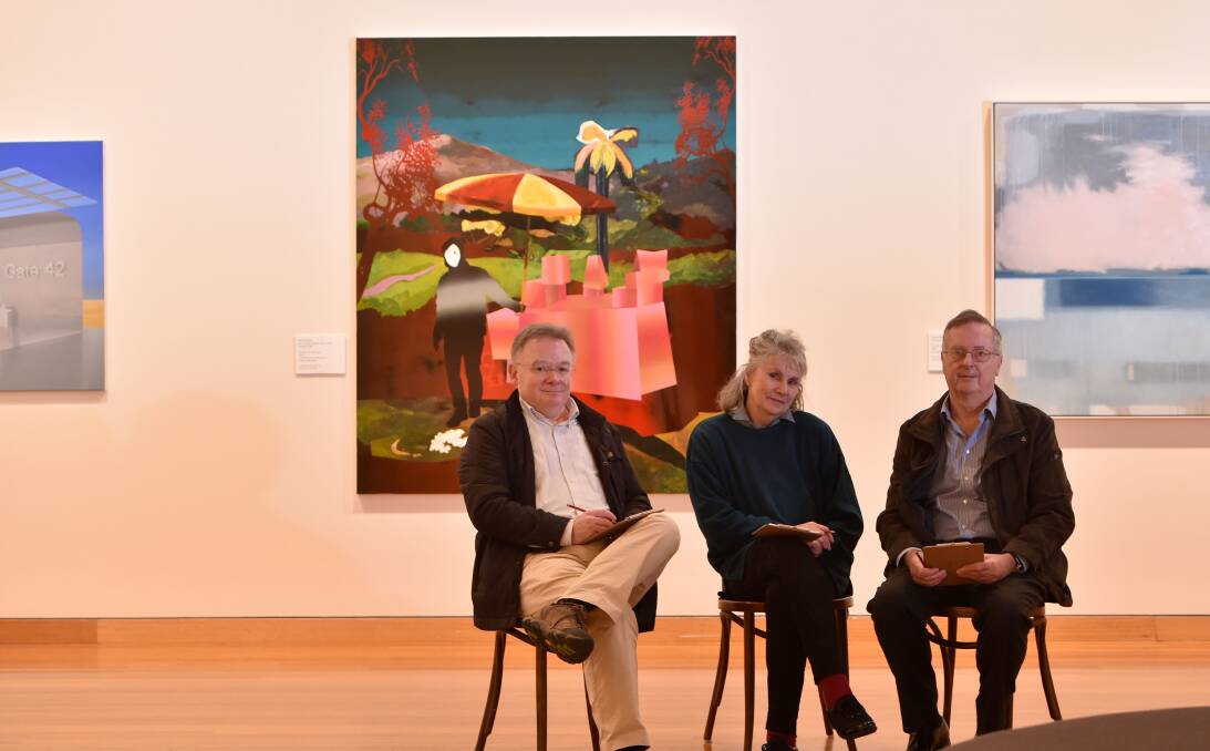 TOUGH JOB: Three of this year’s judges - John McDonald, Julie Millowick and Peter Guy - in front of the Arthur Guy Prize finalists' artwork. Picture: JODIE DONNELLAN