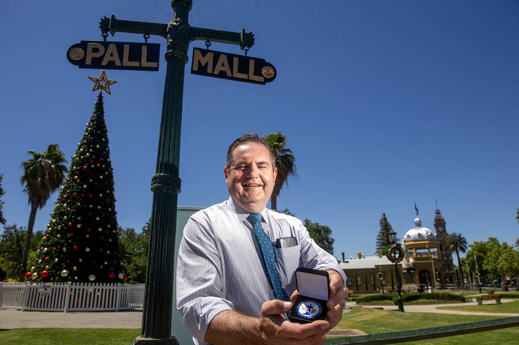 NAME CHANGE: Simon Mulqueen with a medal commemerating the 150th anniversary of the Easter Festival. Picture: DARREN HOWE