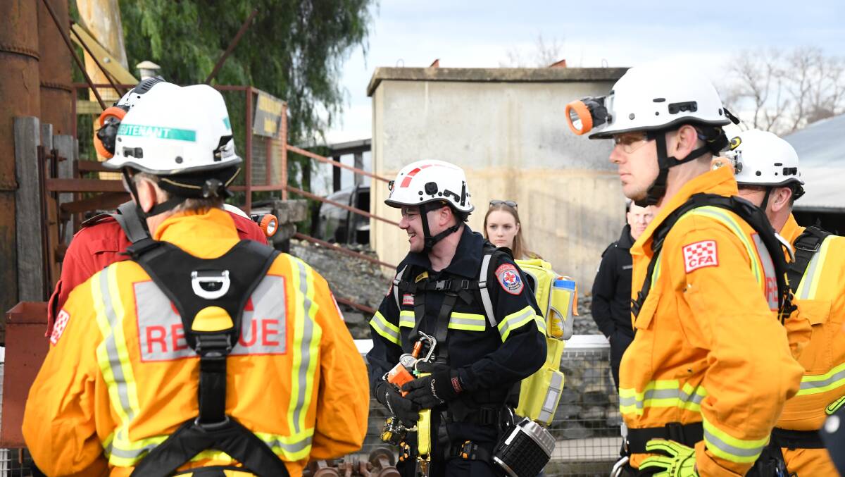 Paramedics Josh King (centre) talks with other emergency services members.