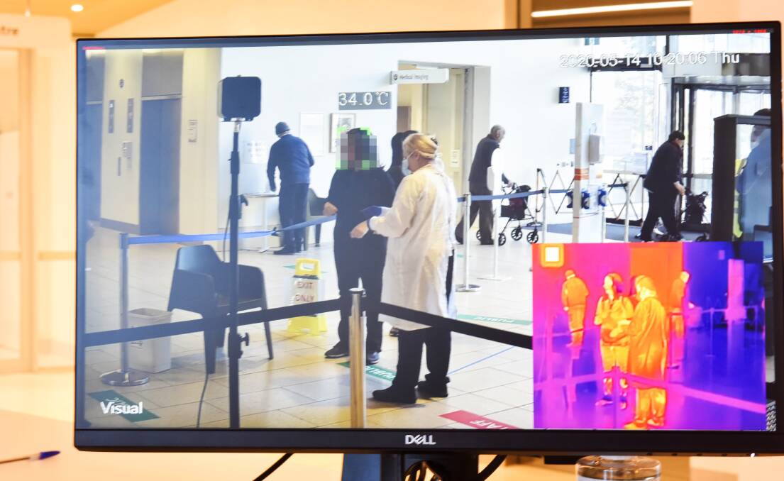 Hospital visitors are scanned by a thermal imaging camera while entering Bendigo Health. Picture: Brendan McCarthy 