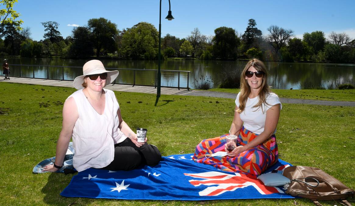 Kellie Daykin and Shonia Cunningham enjoy a coffee in the sun at Lake Weeroona on Sunday. Picture: NONI HYETT