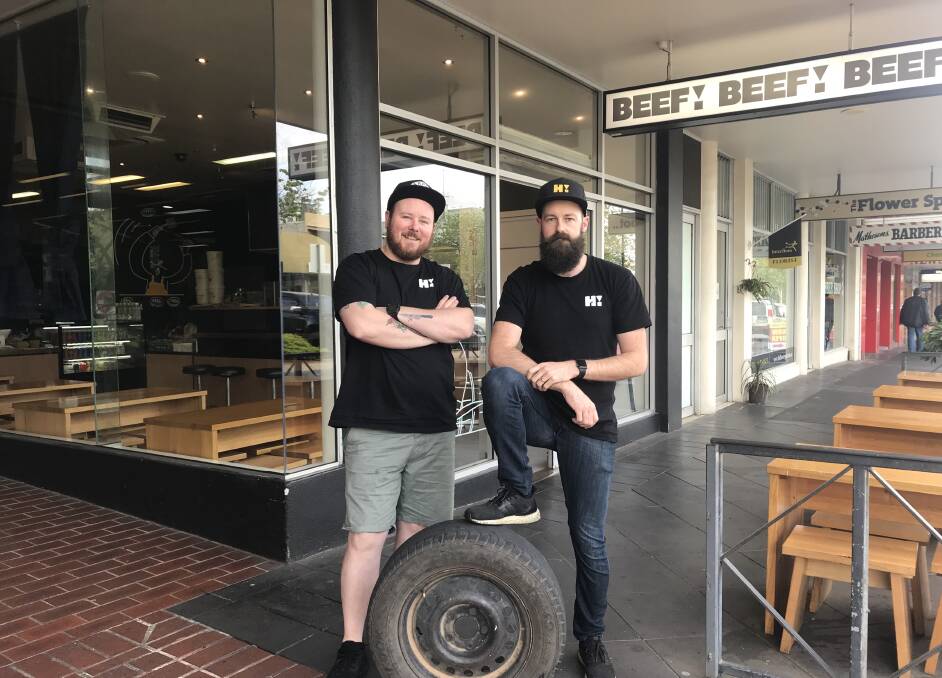 Justin McPhail and Nick Horgan with the tyre that went through their restaurant window. Picture: CHRIS PEDLER