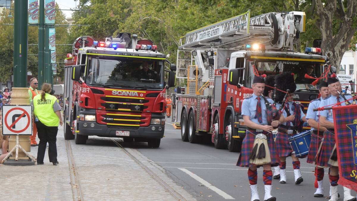 CALLED AWAY: A fire truck attempts to exit the Easter Gala Parade on Sunday after being called to a structure fire in Long Gully. Picture: NONI HYETT