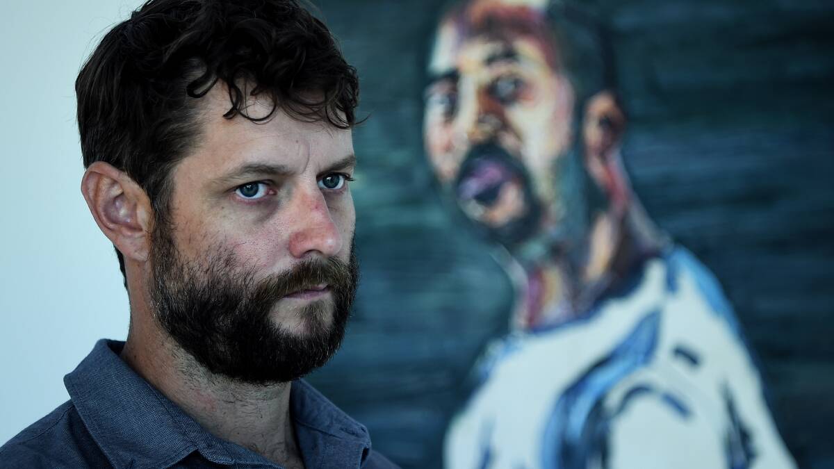 Artist Ben Quilty in front of Myuran Sukumaran's painting 'Self Portrait - Time is Ticking 2015' that is a part of 'Another Day In Paradise' an exhibition. Picture: Kate Geraghty