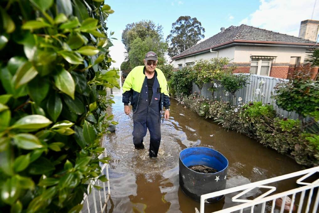 Wayne Edwards inspects his aunty's property, parts of which were still underwater on Sunday afternoon. Picture by Darren Howe.