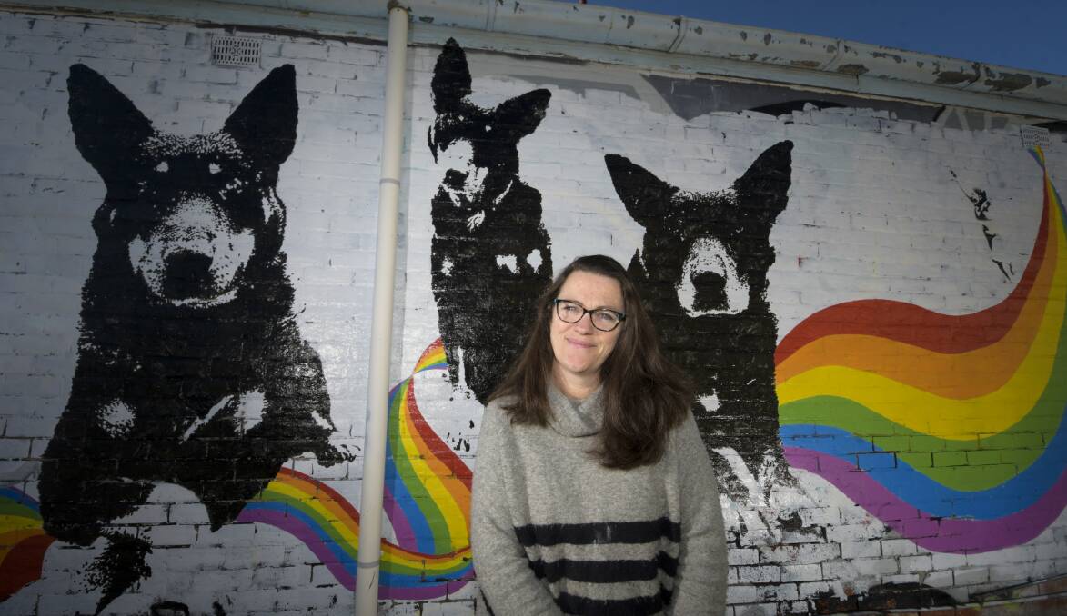 STREET ART: Sarah Wallace-Smith with her Arnold Street Gallery mural It is inspired by her children and the family dogs. Picture: NONI HYETT