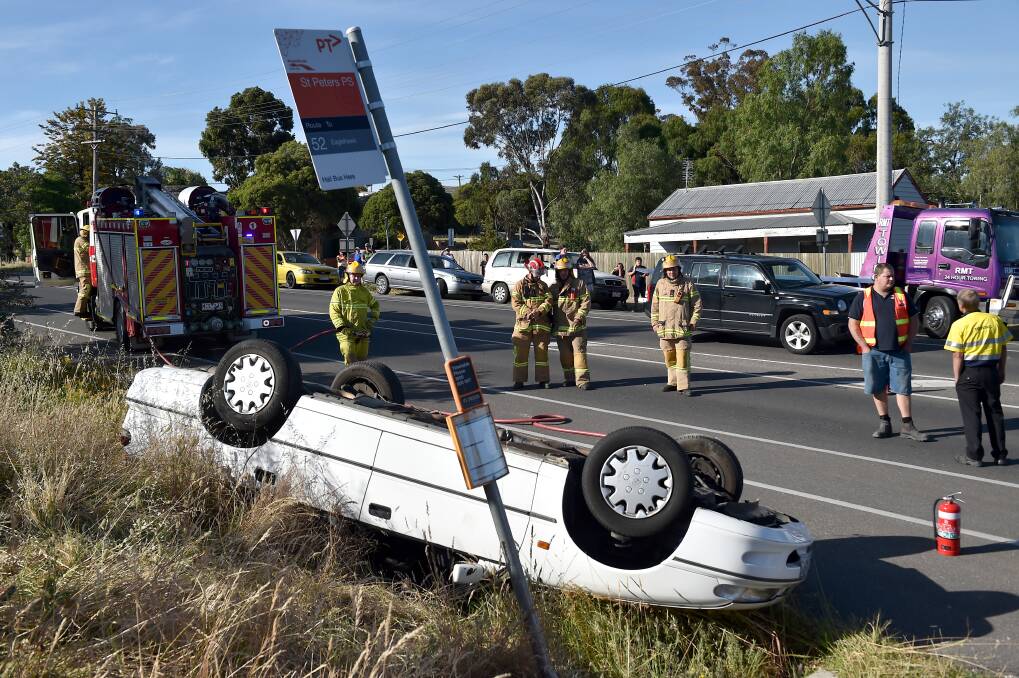 CRASH: Emergency services at the scene of a car rollover in North Bendigo on Friday evening. Picture: NONI HYETT
