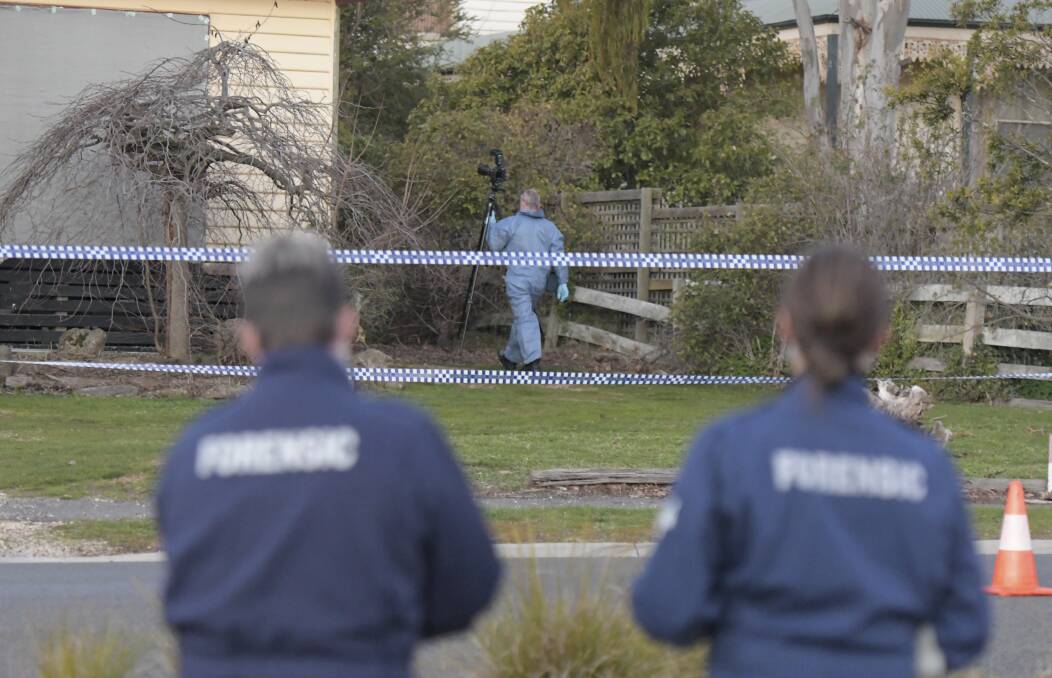 Investigators at the house of John Bourke, who died last year. Picture: NONI HYETT