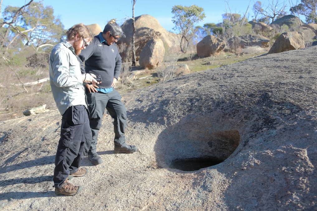 Archaeologist Gavin McDevitt and Dja Dja Wurrung park ranger Sharnie Hamilton, pictured here inspecting a rock well in the park, will both speak at the event.