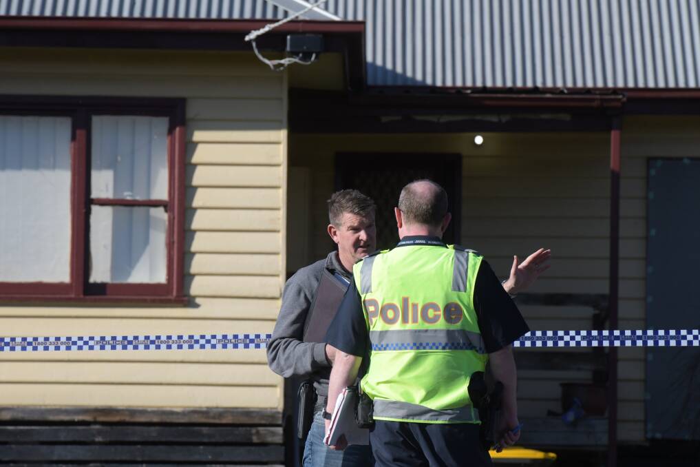 Police outside the home of John Bourke, where the 45-year-old's body was found last July. Picture: NONI HYETT