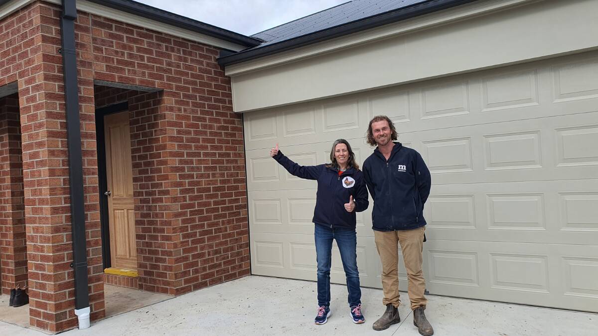 New home owner Sally Blythe with her Metricon site manager Eddy Musial outside her brand new home which was complete in less than five months. Picture Metricon Homes