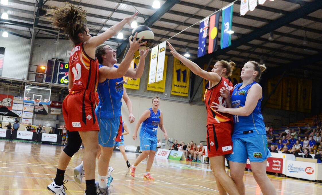 Bendigo Spirit guard Kerryn Harrington looks for a way to the basket under intense pressure from the Townville Fire's Chevannah Paalvast and Darcee Garbin.  Picture: DARREN HOWE
