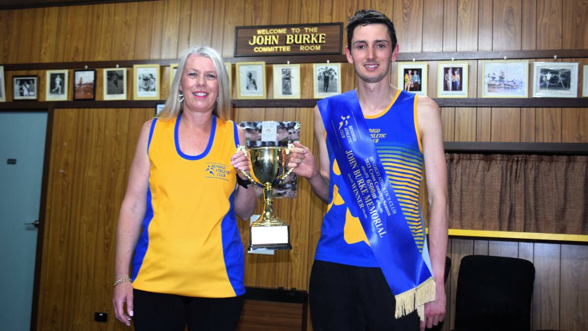 Bendigo Athletic Club president Justine Babitsch with inaugural John Burke Memorial Classic men's winner Michael Preece. The pair are standing in the club's committee room, which is named in honour of the late legendary coach. Picture by Kieran Iles
