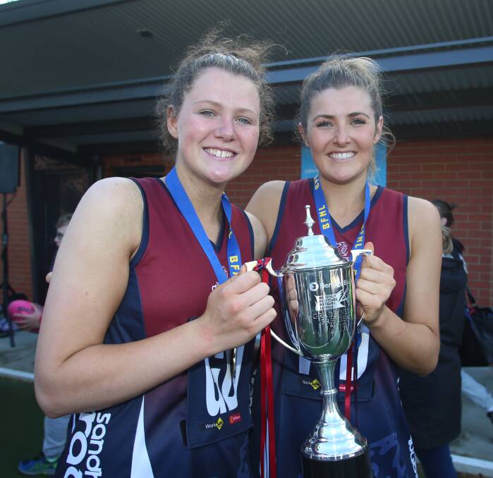 Carly Van Den Heuvel (right) holds the premiership cup with fellow defender Sophie Shoebridge.