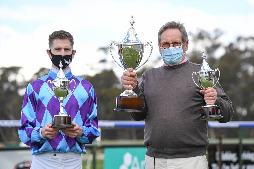 Jockey Jye McNeil and trainer David Brideoake with a swag of Apiam Bendigo Cup trophies. Picture: RACING PHOTOS