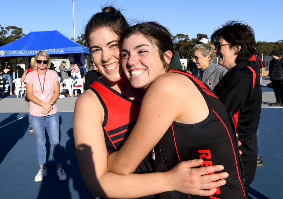 Sisters Nikki and Meg Lockhart embrace after the A-grade grand final win. Picture: NONI HYETT
