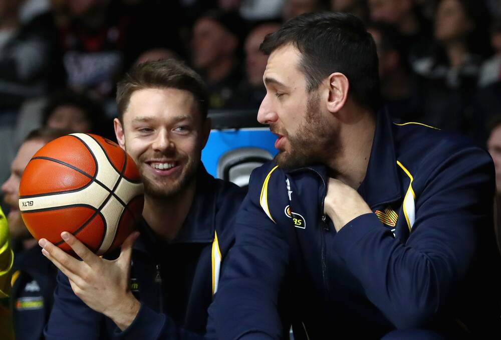 SIDELINED: Matthew Dellavedova and Andrew Bogut take their seat on the bench during the Boomers game against a college all-stars line-up. Picture: GETTY IMAGES