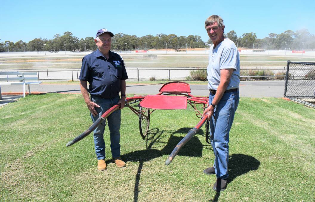 Boort Harness Racing Club president John Campbell and Bendigo Harness Racing Club historian Noel Ridge with the sulky used by Hall of Famer Grand Voyage in the 1921 Boort Pacing Cup. Picture: KIERAN ILES
