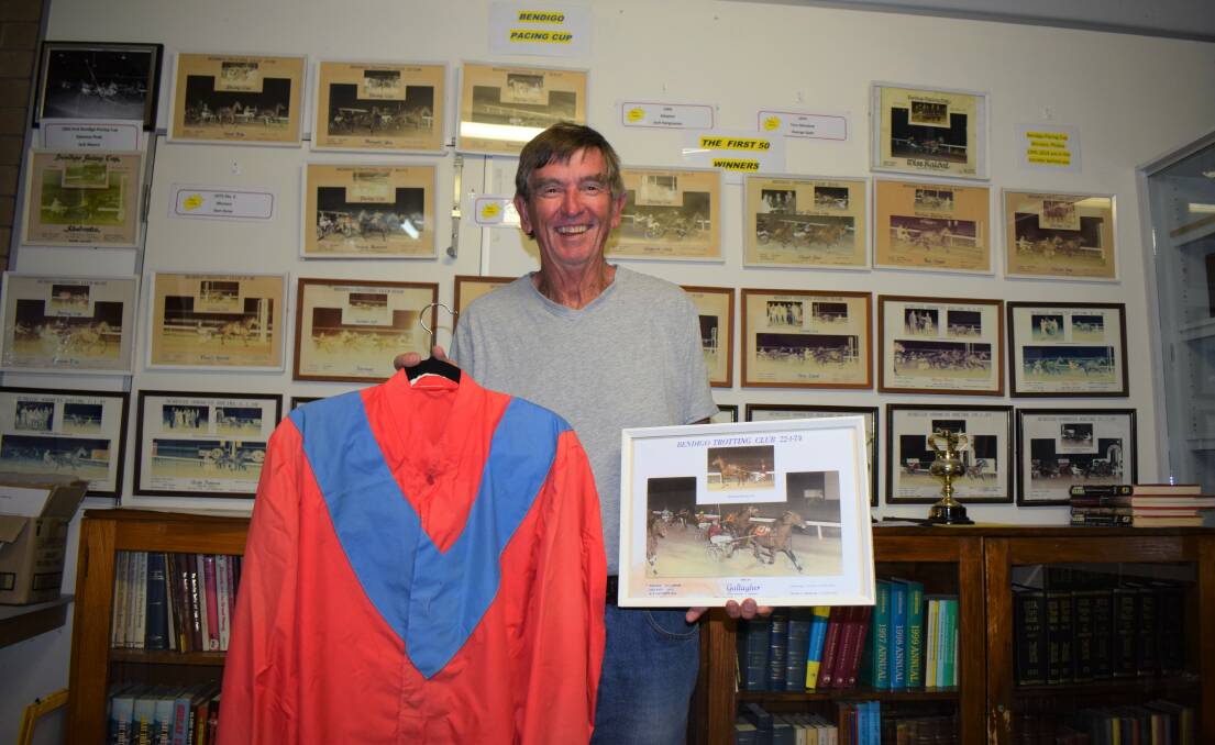 Historian Noel Ridge with a photo of the finish and the silks worn by Gordon Rothacker on the night of Gallagher's 1974 Bendigo Cup win. The photo is one of 53 adorning the walls of the home of the Bendigo Harness Racing Club's history and memorabilia collection. Picture: KIERAN ILES