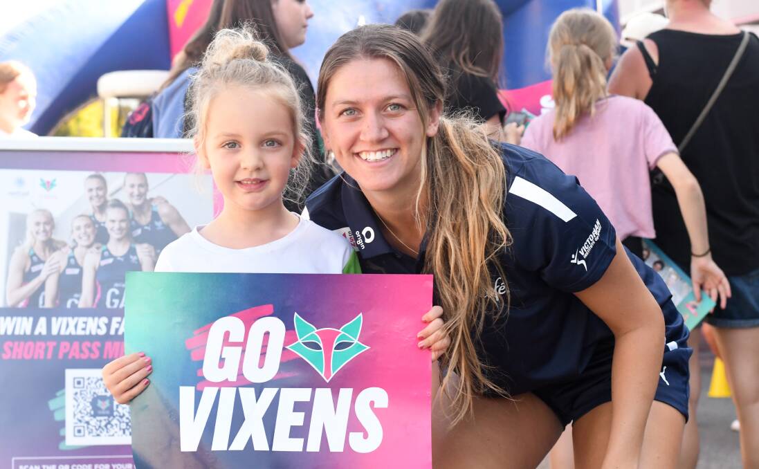 Melbourne Vixens defensive midcourter Kate Eddy with fan Harper Grace during last year's visit to Bendigo by the Super Netball club. The Vixens will be back on Saturday, February 10. Picture by Noni Hyett
