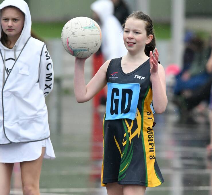 RAIN, HAIL OR SHINE: Youngsters can not get enough of netball. Picture: NONI HYETT