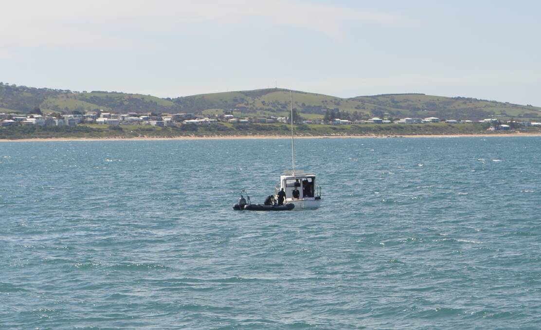 Police speak to Goolwa fisherman Tony Higgins aboard the Margrel on Thursday afternoon. Mr Higgins remains anchored off Granite Island, as of Friday afternoon, September 11. Photo: Jack Manning. 