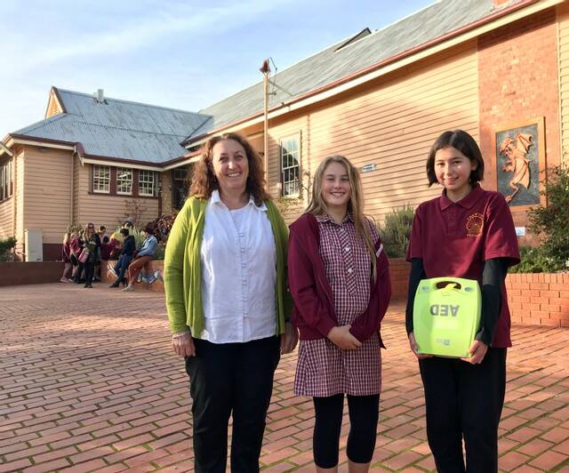 Chewton Primary School principal Bernadette McKenna with senior students accepting an AED.