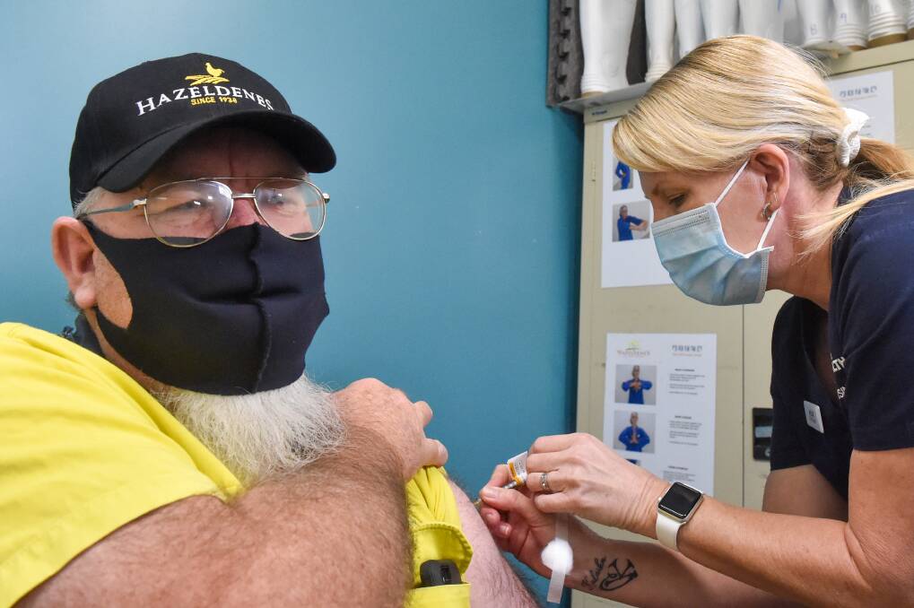 Hazeldene worker Greg Exon receiving his vaccination from Bendigo Health in June. Picture: DARREN HOWE