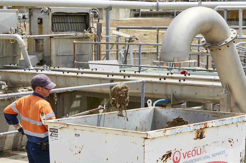 A plant operator at the Bendigo Water Reclamation Plant removing wet wipes and other foreign objects from the pre-treatment screening process. Picture: Supplied