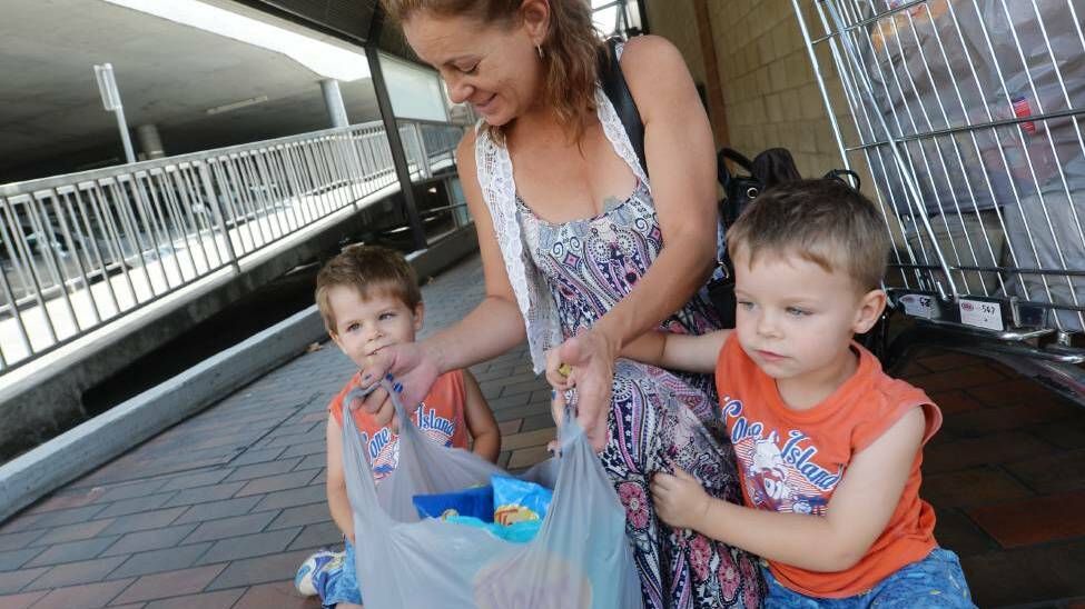 Terrie Steve, with her sons Hunter and Chase, after leaving Coles Bendigo with a trolley full of plastic bags. Picture: DARREN HOWE